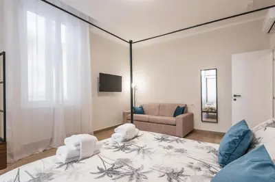 a bedroom with a large bed and a couch at Appartamento fino a 17 persone in centro a 17 minuti a piedi da Piazza di Spagna in Rome
