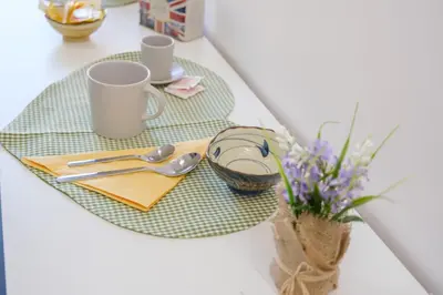 a table with two plates and cups and a vase of flowers at Rome Urban Retreat - Metro A in Rome