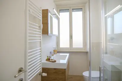 a bathroom with a sink and a toilet and a window at Rome Urban Retreat - Metro A in Rome