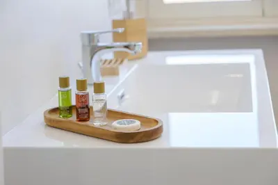 a bathroom sink with a tray with three bottles of essential oils at Rome Urban Retreat - Metro A in Rome