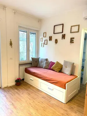 a bed in the corner of a room at Happy House with private garden in Rome