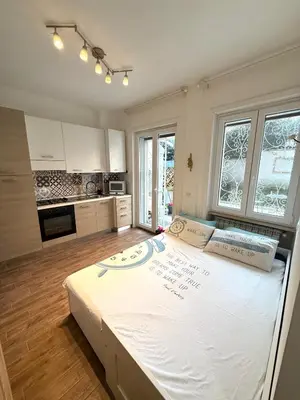 a large bed in a room with a kitchen at Happy House with private garden in Rome