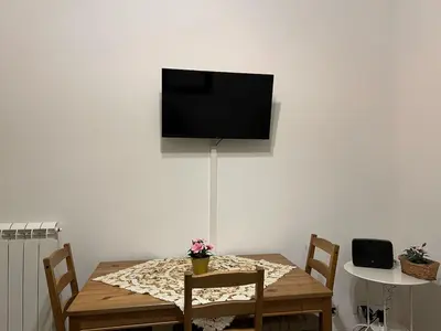 a dining room table with a television on a wall at Saint Peter & Giulio Cesare in Rome