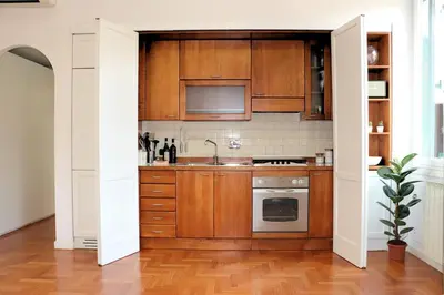 a kitchen with wooden cabinets and a sink at Saint Bon Dream in Rome
