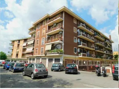 a large building with cars parked in a parking lot at Banksy house in Rome intero appartamento in Rome