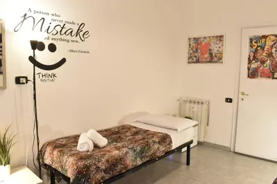 a bedroom with a bed with a mallie sign on the wall at Banksy house in Rome intero appartamento in Rome