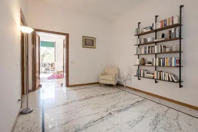 a living room with a chair and a book shelf at Eleganza&Confort in Roma-Liberty- in Rome