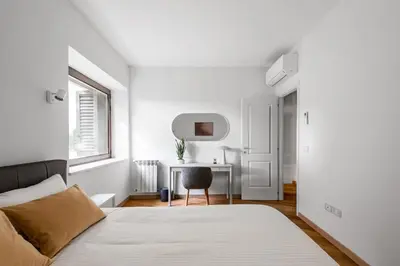 a white bedroom with a bed and a desk at The Spiral Way - Trastevere apartment with large private terrace in Rome