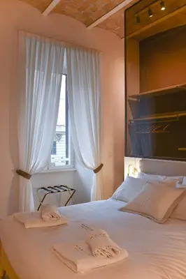 a bedroom with a bed with two towels on it at Maralf Urban Suites in Rome