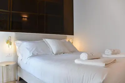 a white bed with two towels on top of it at Maralf Urban Suites in Rome