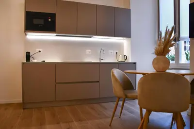 a kitchen with a sink and a table and chairs at Maralf Urban Suites in Rome