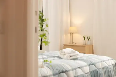 a white bed with a pile of towels on it at Appartamento Gemelli - Val Favara Apartment in Rome