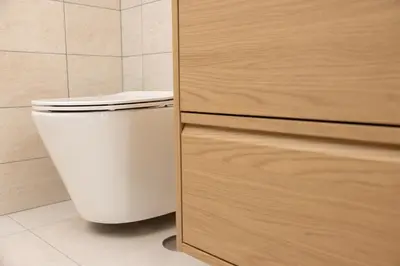 a white toilet in a bathroom next to a wooden cabinet at Appartamento Gemelli - Val Favara Apartment in Rome