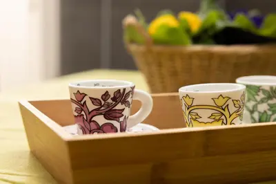 three coffee cups sitting in a wooden tray at Appartamento Gemelli - Val Favara Apartment in Rome
