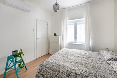 a white bedroom with a bed and a window at Vatican Manu Home in Rome