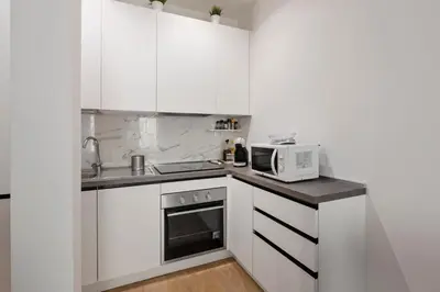 a kitchen with white cabinets and a microwave at Vatican Manu Home in Rome