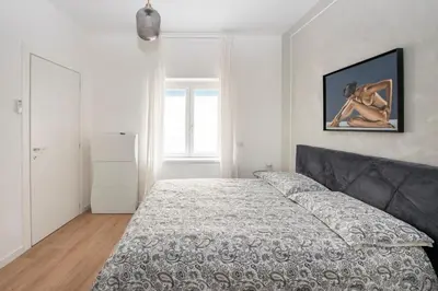a bedroom with a bed in a white room at Vatican Manu Home in Rome
