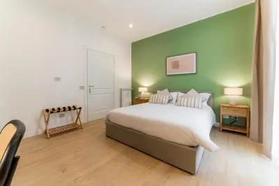 a bedroom with a bed and a green wall at Giano Vatican Suites - Metro Cipro in Rome
