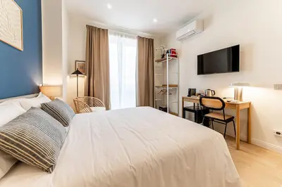 a bedroom with a bed and a desk and a television at Giano Vatican Suites - Metro Cipro in Rome