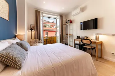 a bedroom with a bed and a desk with a computer at Giano Vatican Suites - Metro Cipro in Rome
