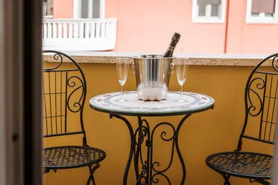 a table with two wine glasses and a bottle on it at Giano Vatican Suites - Metro Cipro in Rome