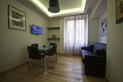 a living room with a table and chairs and a couch at Piramide House in Rome