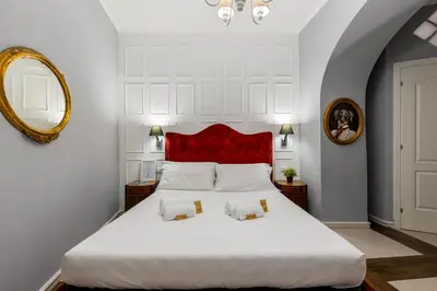 a bedroom with a large white bed with a red headboard at Domus 15 - Guest House in Rome