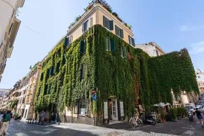 a building covered in green ivy on a street at Domus 15 - Guest House in Rome