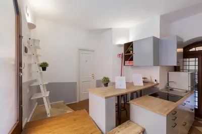 a kitchen with white cabinets and a wooden counter top at Domus 15 - Guest House in Rome