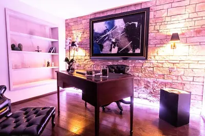 a room with a desk and a brick wall at Reco Luxury Suite Rome in Rome