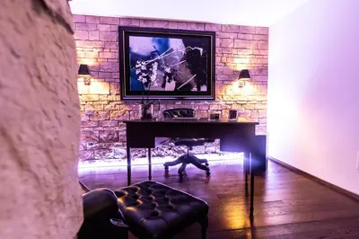 a living room with a table and a stone wall at Reco Luxury Suite Rome in Rome