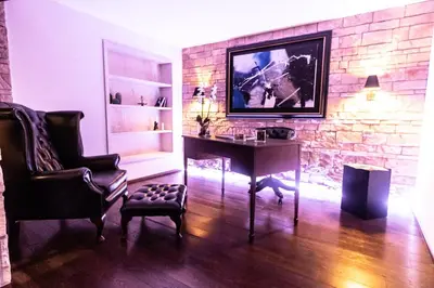 a living room with a table and a tv on a brick wall at Reco Luxury Suite Rome in Rome