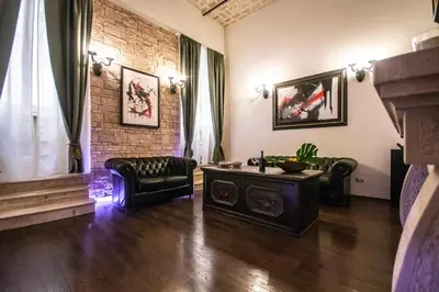 a living room with leather furniture and a brick wall at Reco Luxury Suite Rome in Rome