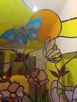 a stained glass window with a flower and a butterfly at Apartment in Trastevere 41 in Rome