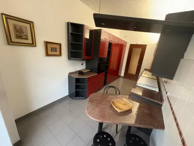 a kitchen with red cabinets and a table in it at Apartment in Trastevere 41 in Rome
