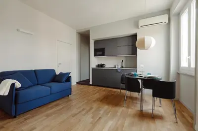 a living room with a blue couch and a table at Pinturicchio's Rooms at Flaminio in Rome