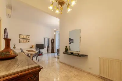 a living room with a table and a mirror on the wall at GuestHost - Zia Pina's Apartment in Rome