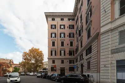 a tall building with cars parked on a city street at GuestHost - Zia Pina's Apartment in Rome