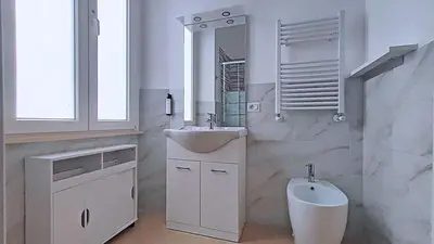 a white bathroom with a sink and a mirror at Collection39 Scipioni Luxury Penthouse in Rome