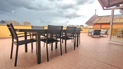 a black table and chairs on a roof at Collection39 Scipioni Luxury Penthouse in Rome