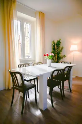 a white dining room table with chairs and a plant at Collection39 Scipioni Luxury Penthouse in Rome