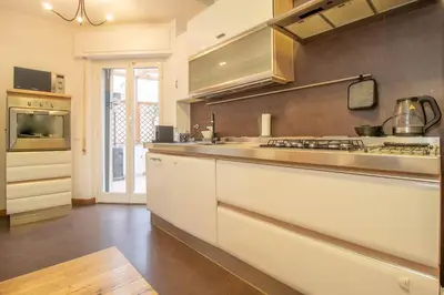 a large kitchen with white cabinets and a stove at A casa di Carlo Roma Vaticano in Rome