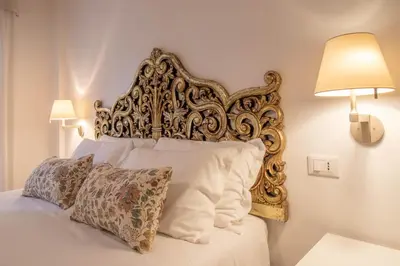 a bed with a large ornate headboard in a bedroom at A casa di Carlo Roma Vaticano in Rome