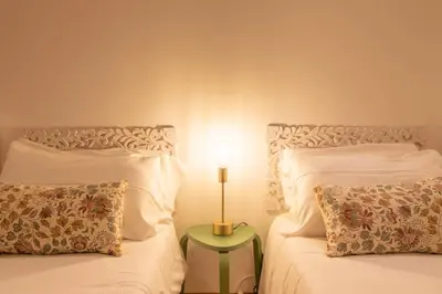 a bedroom with two beds and a lamp on a table at A casa di Carlo Roma Vaticano in Rome