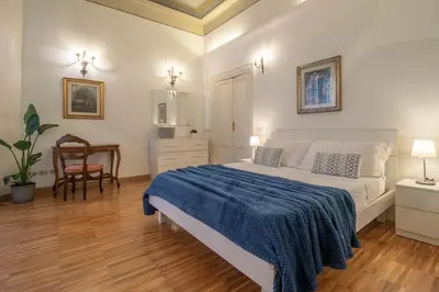 a bedroom with a bed with a blue blanket on it at Casa Nicalandro Roma Centro in Rome