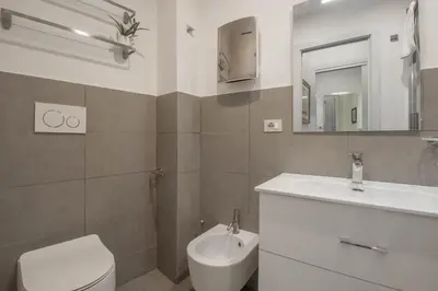a bathroom with a sink and a toilet and a mirror at Casa Nicalandro Roma Centro in Rome