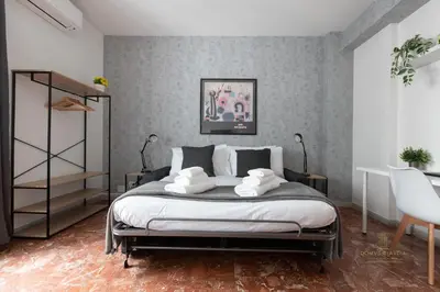 a bedroom with a bed and a table and a chair at Domvs Clavdia - 7min to Colosseum by Metro, Station under apt, Roma, 6pax, A-C in Rome