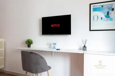 a desk with a chair and a tv on a wall at Domvs Clavdia - 7min to Colosseum by Metro, Station under apt, Roma, 6pax, A-C in Rome