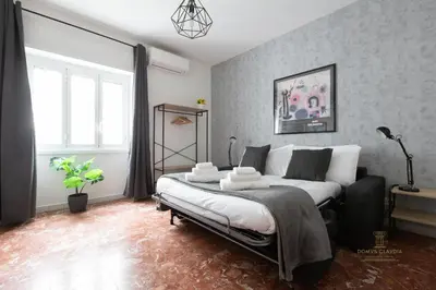 a bedroom with a large bed in a room at Domvs Clavdia - 7min to Colosseum by Metro, Station under apt, Roma, 6pax, A-C in Rome
