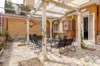 a patio with black chairs and an umbrella at Casa Polly in Rome